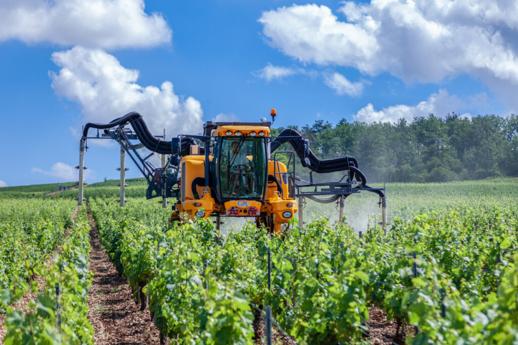 photo showing tractor spraying inside a vineyard