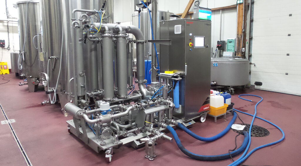 winery equipment with many hoses and draining into the floor of a winery